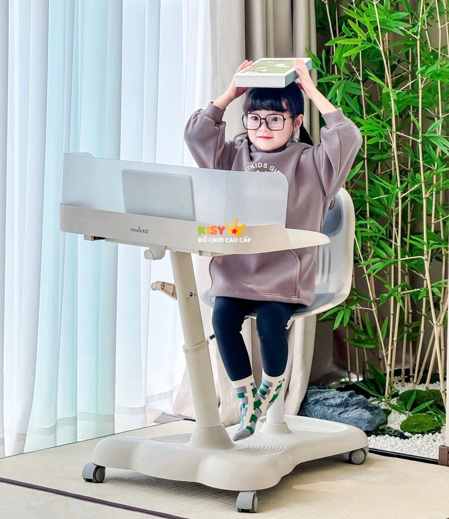 Bé đội sách trên đầu, ngồi thẳng lưng tại bàn