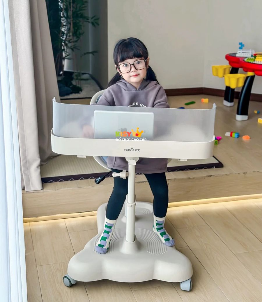 Bé ngồi tại bàn học đặt trong phòng chơi