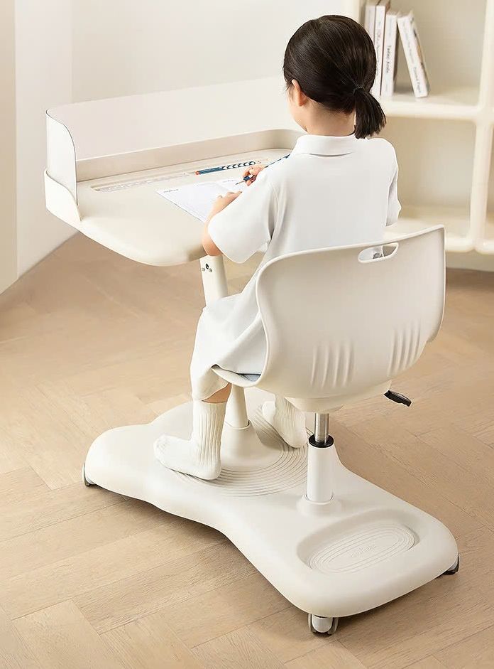 Bé ngồi học sau tấm vách che mờ ở mép bàn